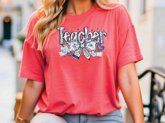 a woman wearing a red teacher shirt and jeans