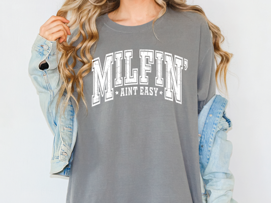 a woman wearing a grey shirt with the word milen printed on it