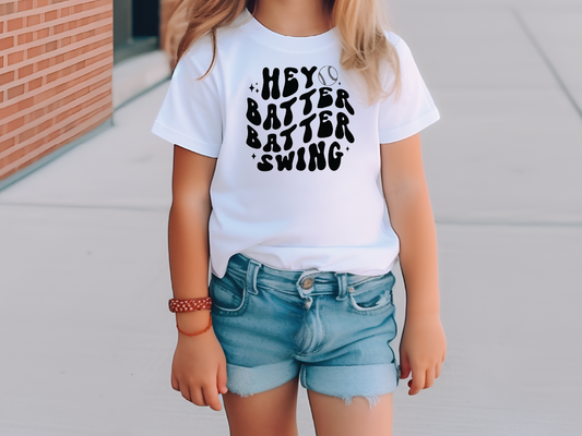 a little girl standing on a sidewalk wearing a white shirt