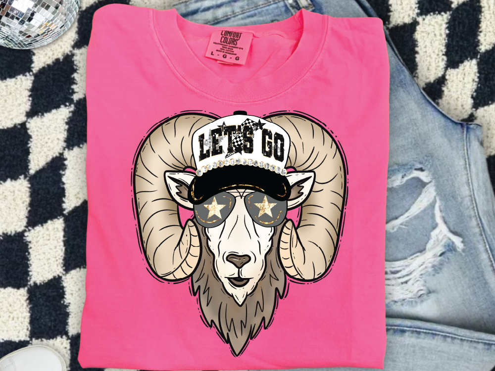 A pink t-shirt with a graphic design of a ram wearing sunglasses and a hat with the text "LET'S GO" printed on it.