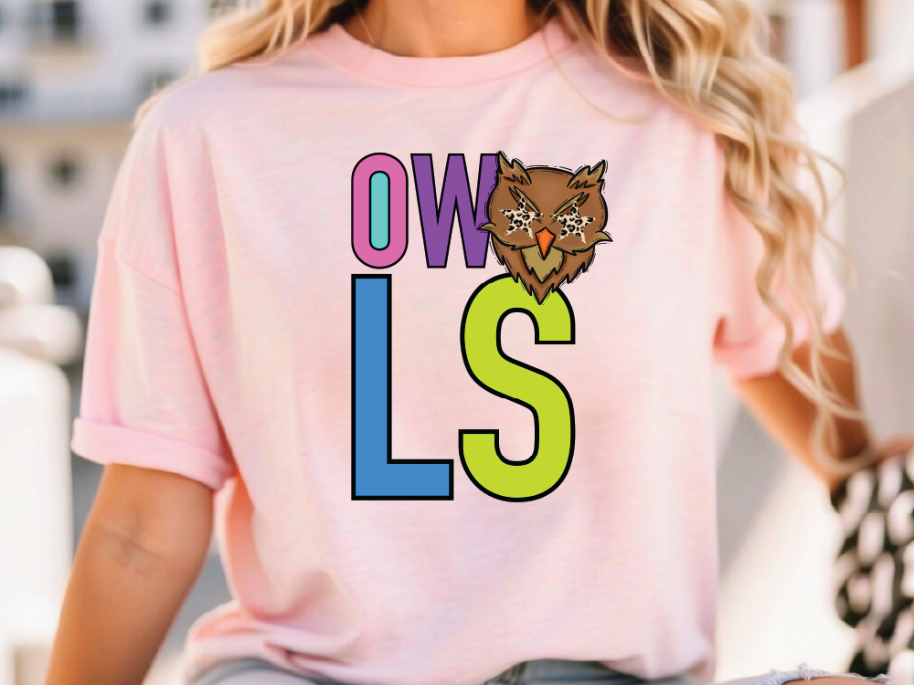 A woman wearing a pink t-shirt with the letters "OWL" and a cartoon owl graphic printed on it.