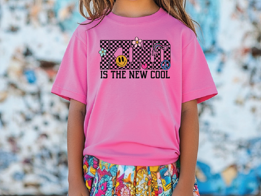 a little girl wearing a pink shirt with a black and white checkerboard design
