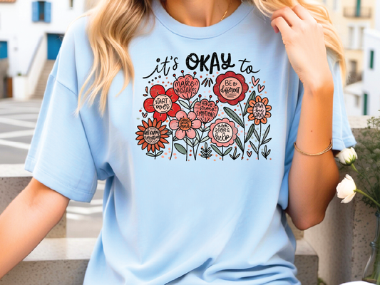 a woman wearing a blue shirt with flowers on it