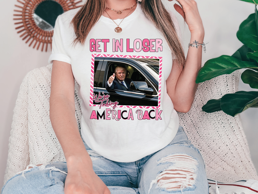 a woman wearing a t - shirt with a picture of a man in a car