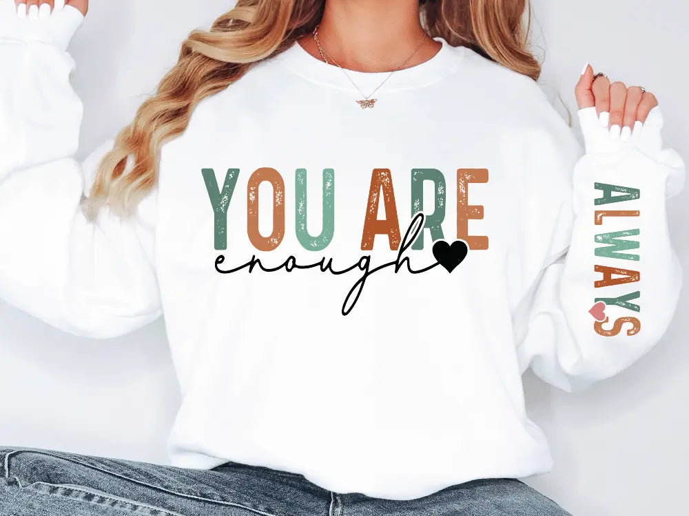 a woman wearing a sweatshirt that says you are enough