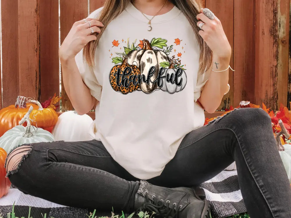 a woman sitting on the ground in front of pumpkins