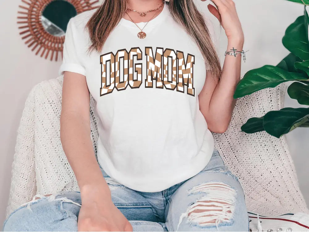 a woman sitting on a couch wearing a dog mom shirt