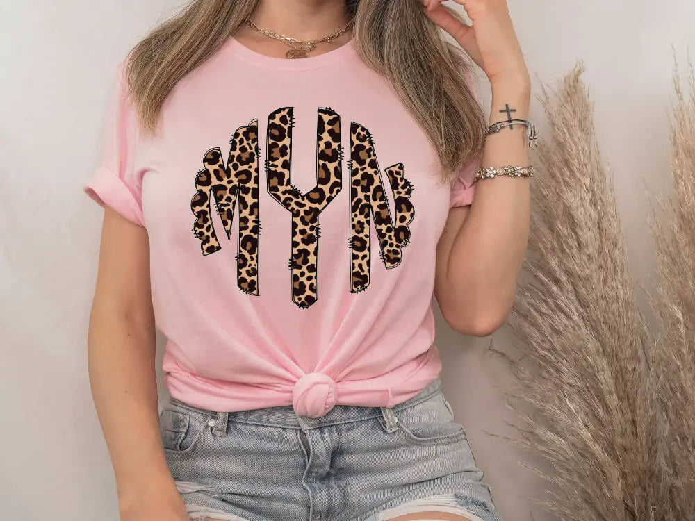 a woman wearing a pink shirt with a leopard print on it