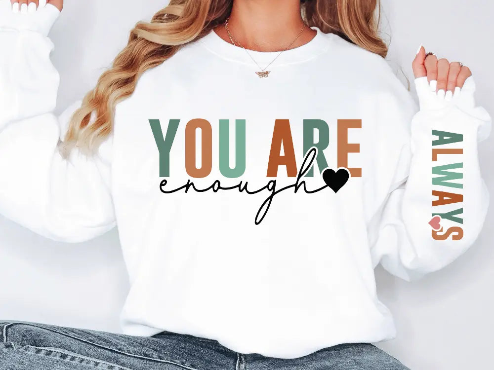 a woman wearing a sweatshirt that says you are enough