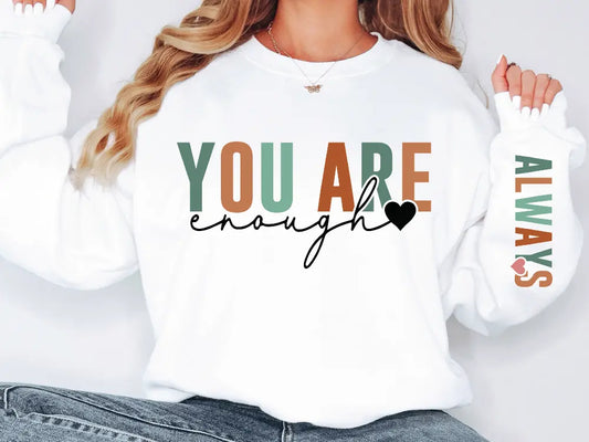 a woman wearing a sweatshirt that says you are enough