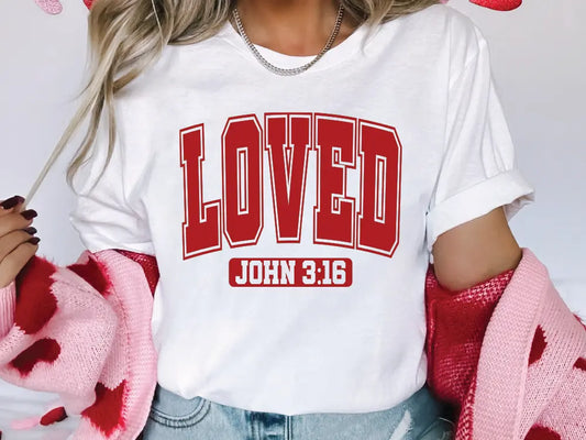 a woman wearing a white shirt with the word loved printed on it