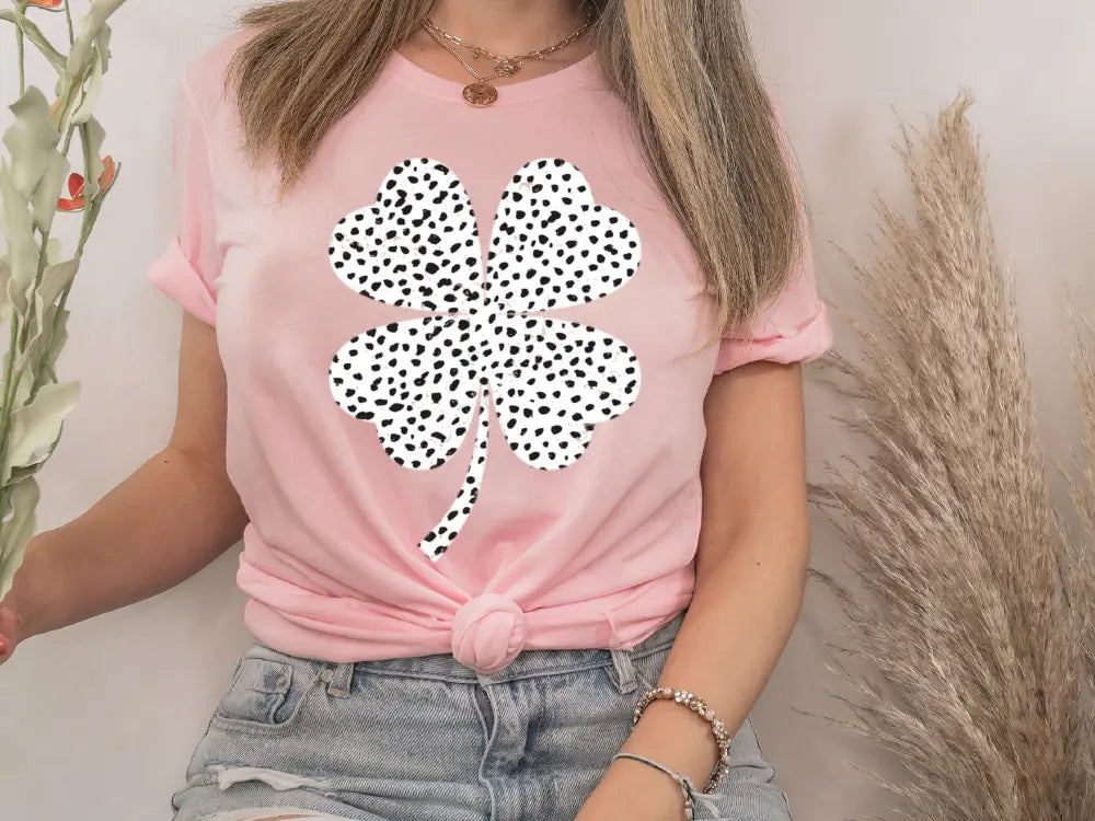 a woman wearing a pink shirt with a four leaf clover on it