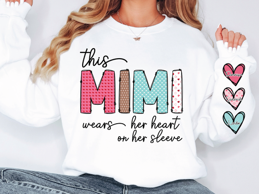 a woman wearing a sweatshirt that says, this mimi wears her heart on her sleeve