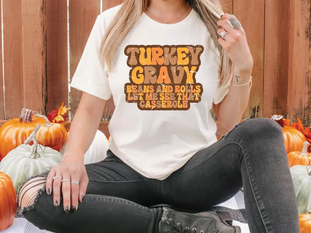 a woman sitting on a table with pumpkins in the background