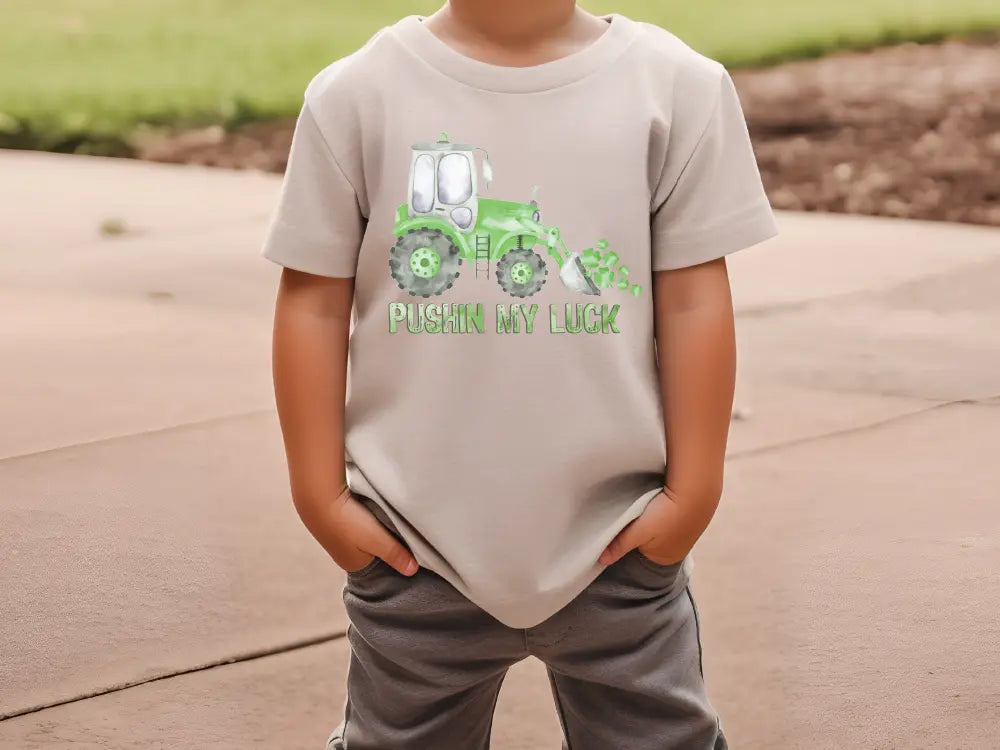 a young boy wearing a t - shirt with a tractor on it