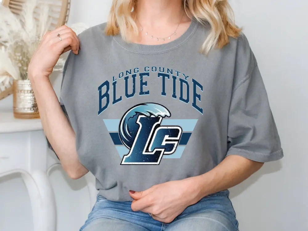 a woman sitting on a chair wearing a blue tide shirt