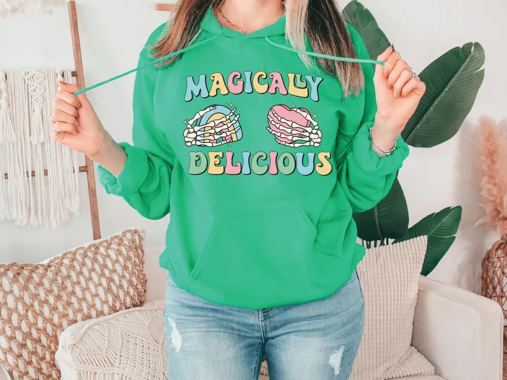 a woman wearing a green hoodie holding a pair of scissors