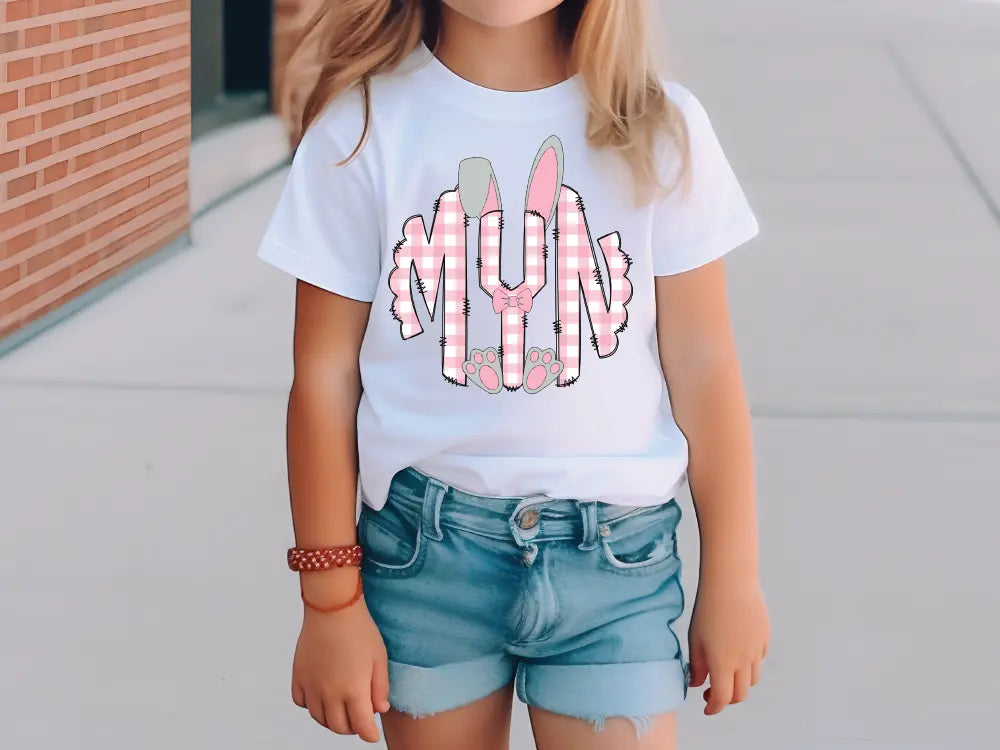 a little girl wearing a white shirt and denim shorts