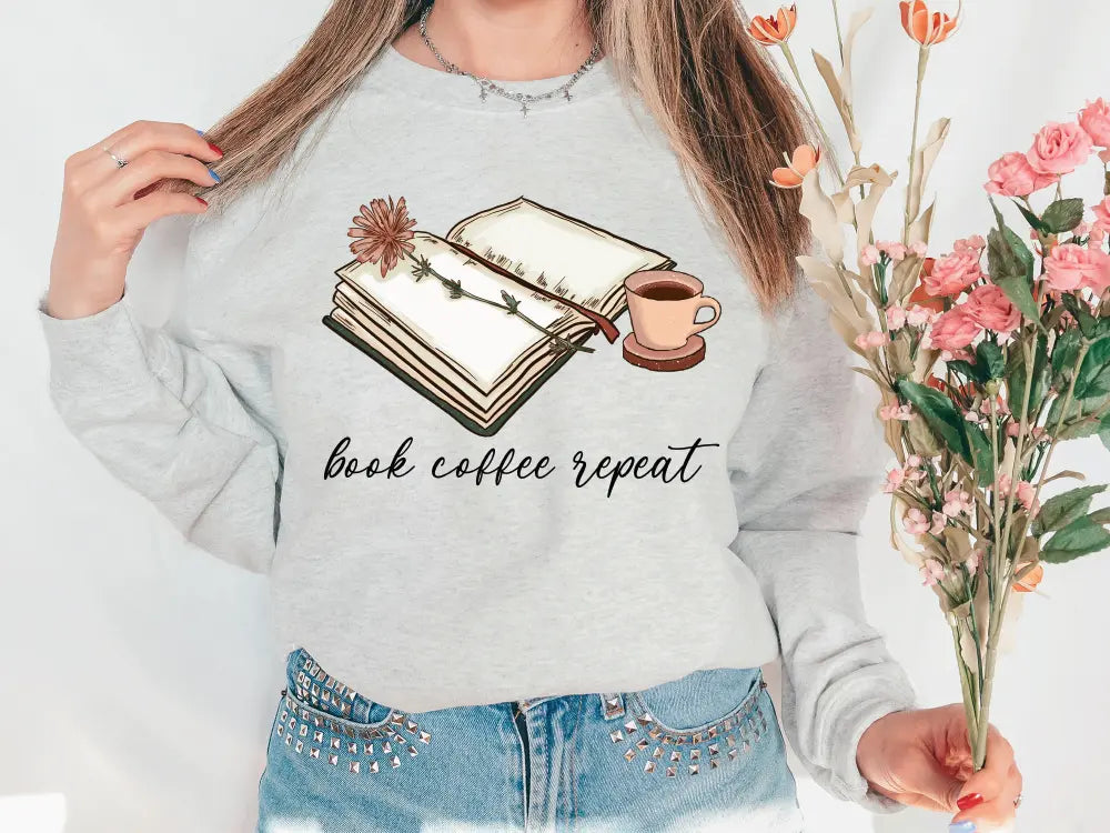 a woman holding a bouquet of flowers and a book sweatshirt