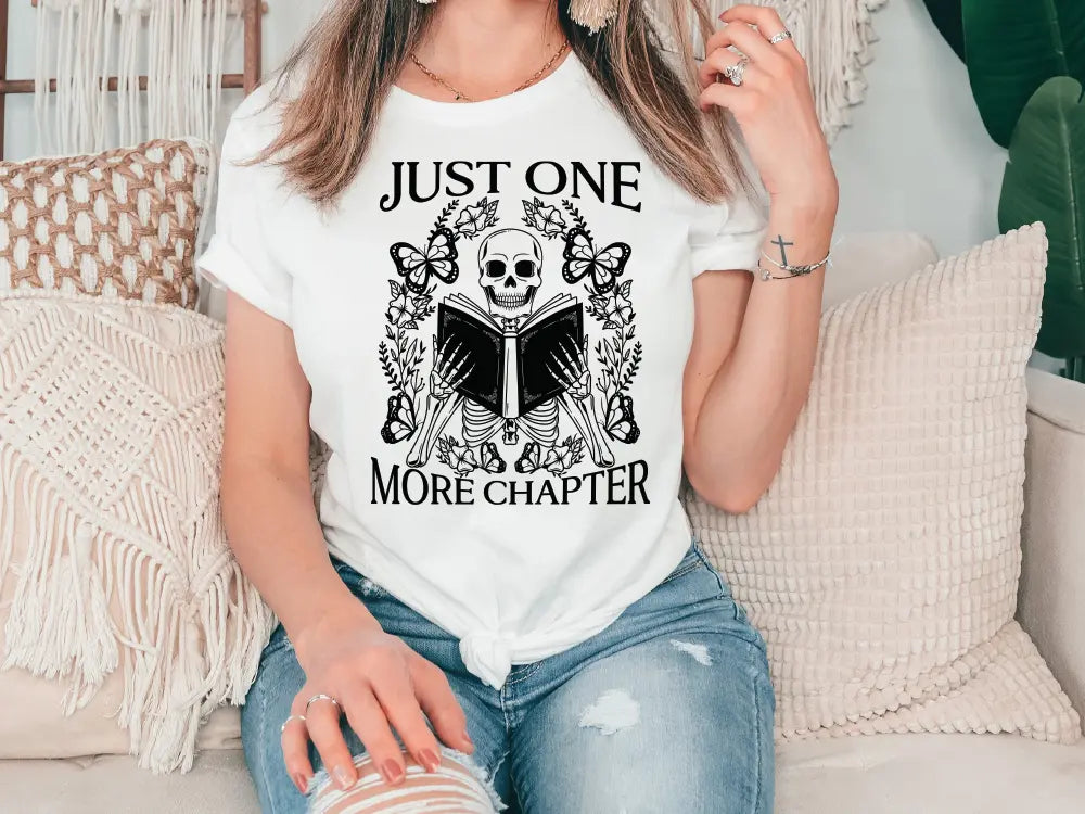 a woman sitting on a couch wearing a t - shirt that says just one more