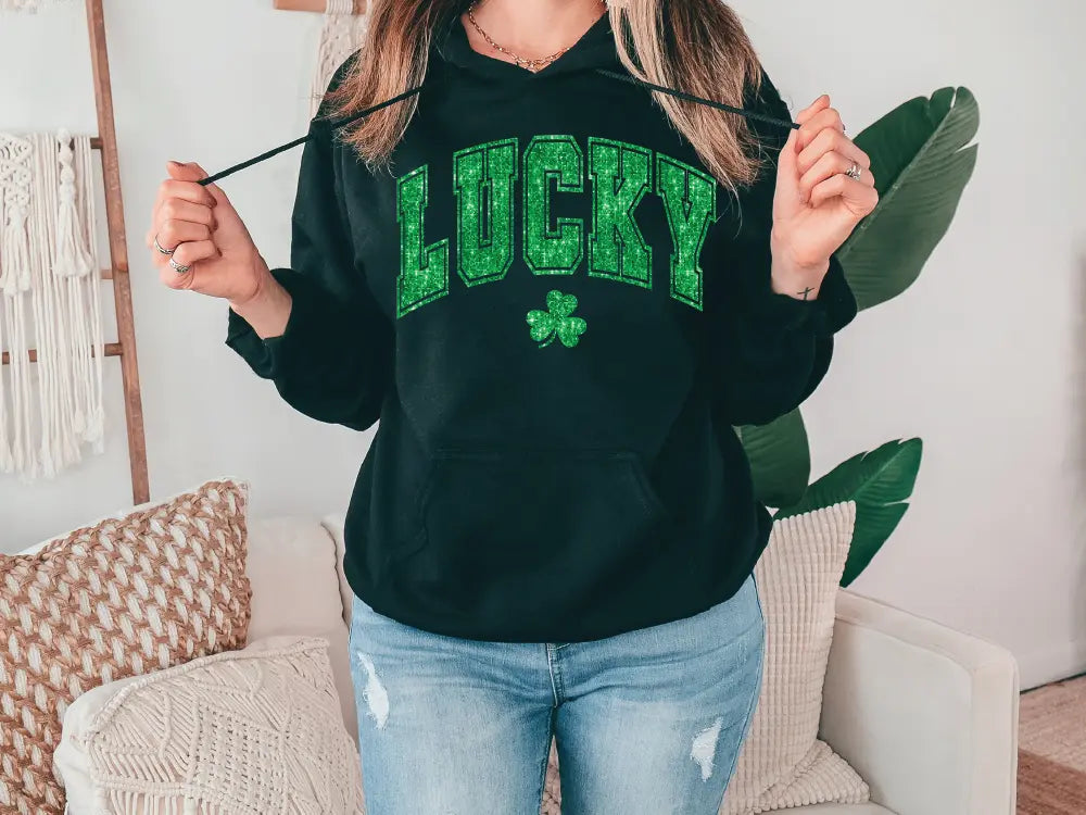 a woman in a black hoodie holding a green leaf