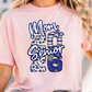 A woman wearing a pink t-shirt with a graphic design that says "Mom of a Senior 2016".
