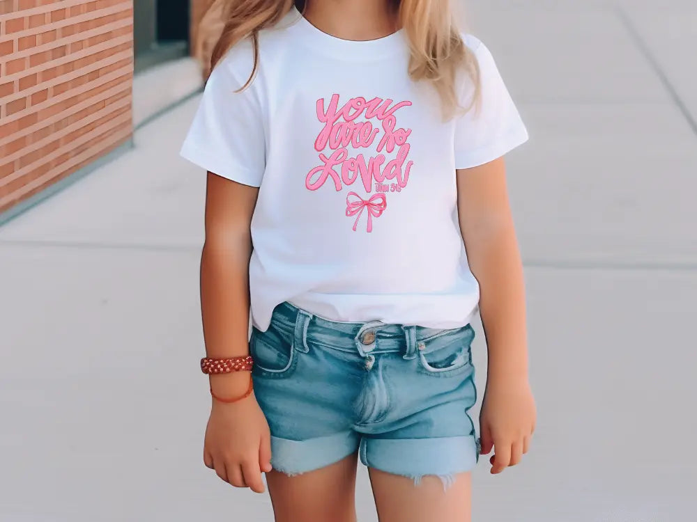 a little girl wearing a white shirt and blue shorts