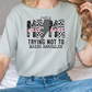 a woman sitting on a bed wearing a t - shirt
