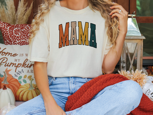 a woman sitting on a couch wearing a shirt that says mama