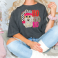 a blonde woman sitting on a bed wearing a shirt with a dog on it