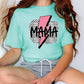 a woman sitting on a chair wearing a t - shirt with a lightning bolt on