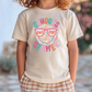 A child wearing a white t-shirt with a colorful graphic design that says "School's out for summer" and sunglasses.
