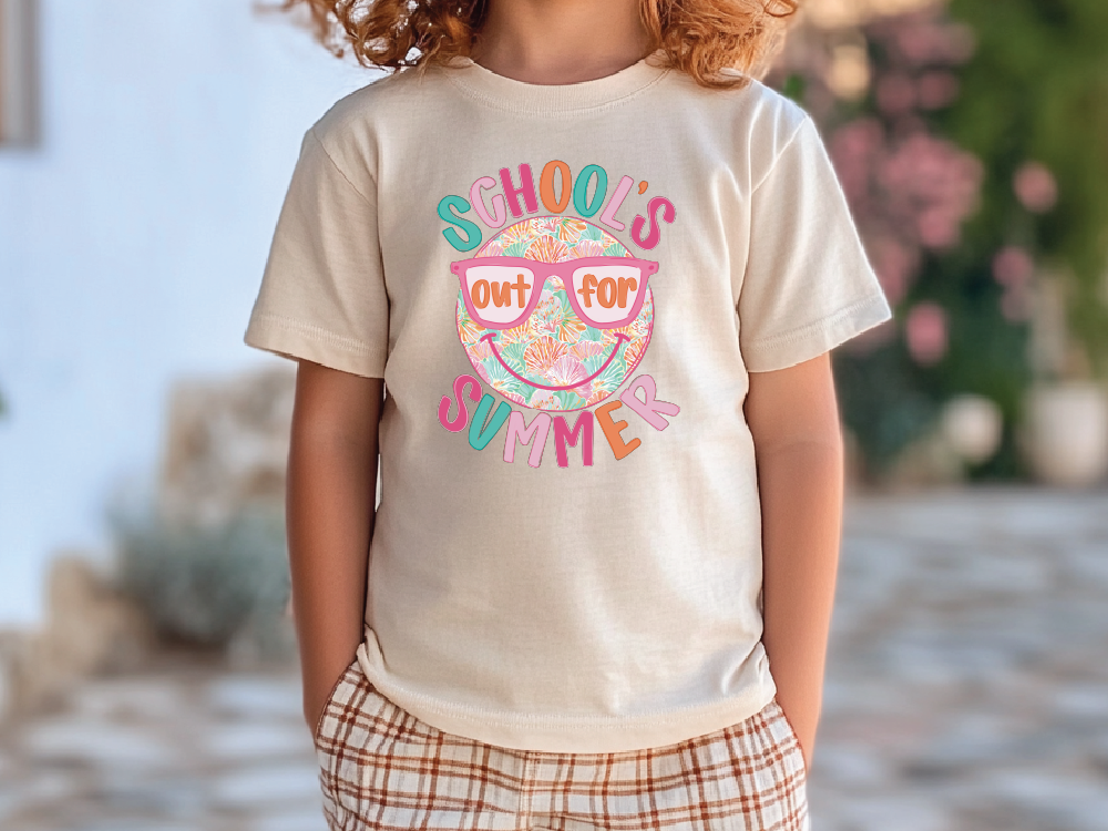 A child wearing a white t-shirt with a colorful graphic design that says "School's out for summer" and sunglasses.