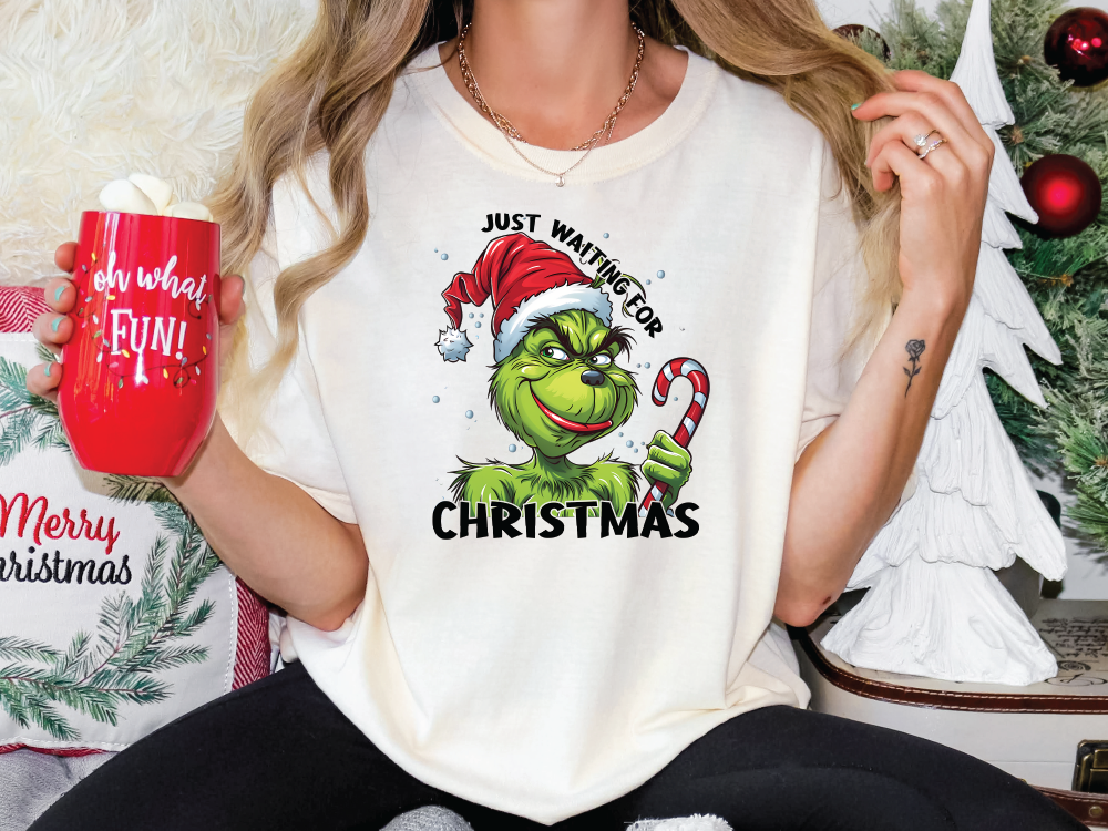 a woman holding a red mug in front of a christmas tree