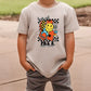 a young boy standing on a sidewalk wearing a t - shirt