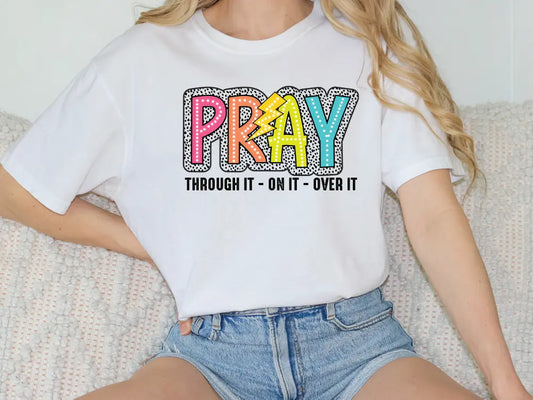 a woman sitting on a couch wearing a t - shirt that says pray through it