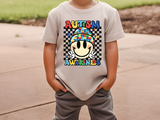 a young boy wearing a autism awareness shirt