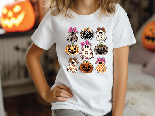 A person wearing a white t-shirt with a graphic design of nine cartoon pumpkins and ghost characters.