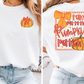 A white sweatshirt with a pumpkin patch design and text on the back.