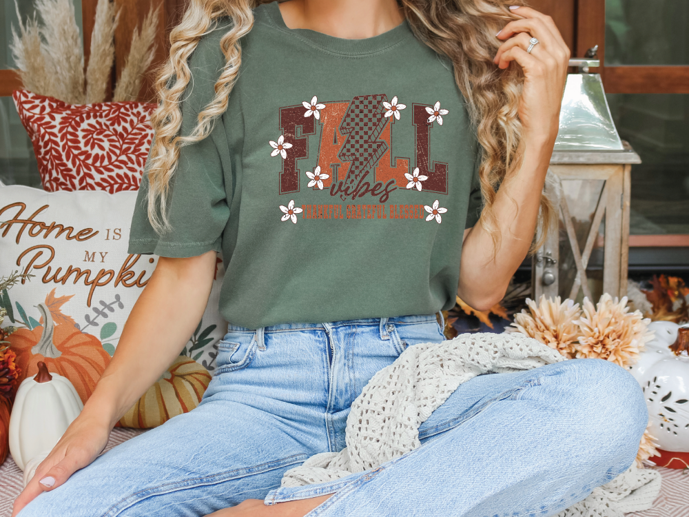 a woman sitting on a bed wearing a t - shirt that says fall