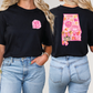 two women wearing black shirts with pink letters on them