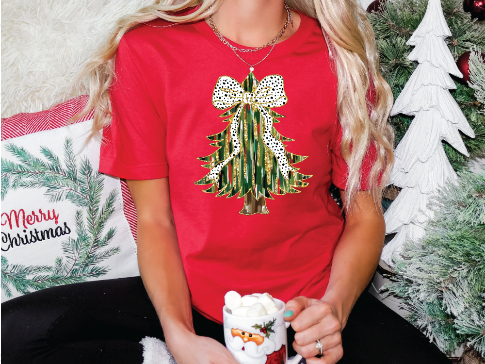 a woman in a red shirt is holding a christmas ornament