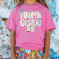 a little girl wearing a pink shirt and colorful shorts
