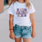 a little girl wearing a white shirt and jean shorts