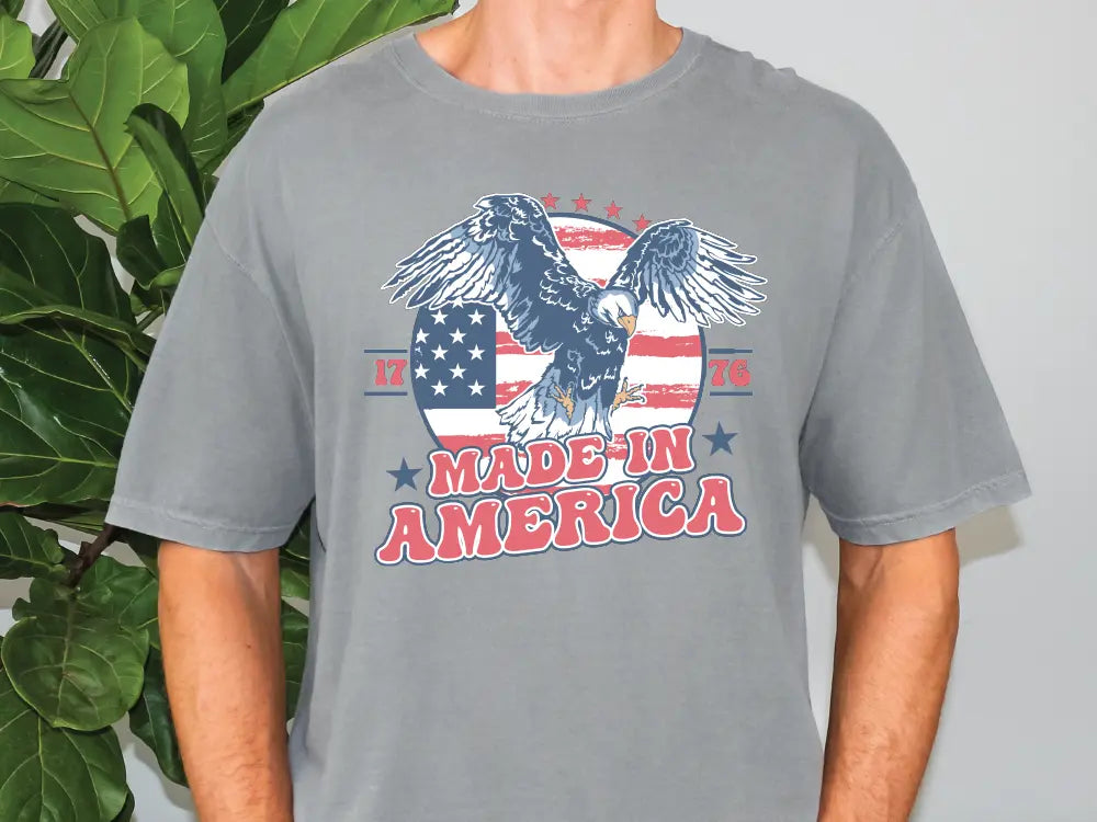 a man wearing a gray t - shirt with an eagle on it