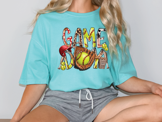 a woman sitting on a table wearing a t - shirt with a baseball glove and