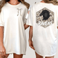 two women wearing white t-shirts with a graphic design on the back.