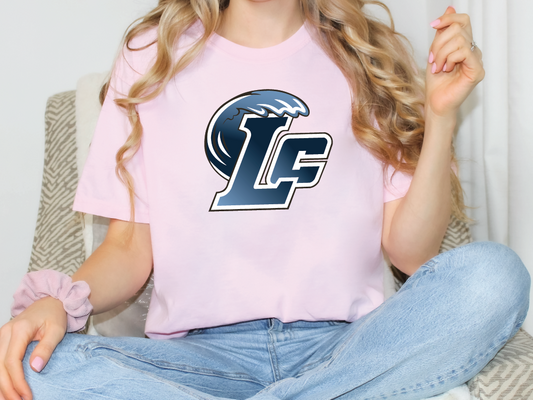 a woman sitting on a couch wearing a pink shirt