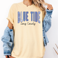 A woman wearing a yellow t-shirt with the text "BLUE TIDE Long County" printed on it, along with a denim jacket.