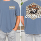 a man wearing a blue t-shirt with a cartoon cowboy character and the text "COLONELS" printed on the back.